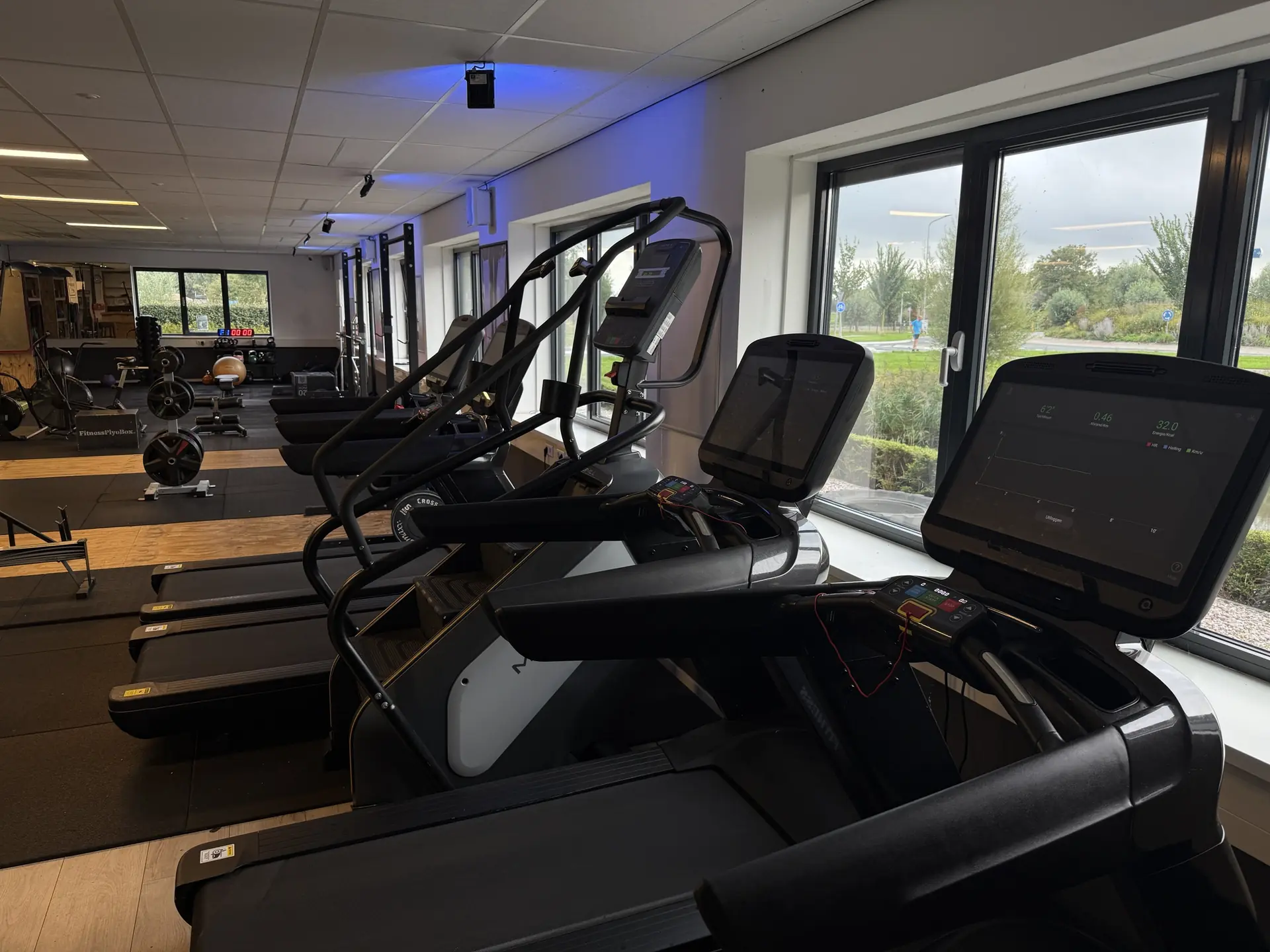 Loopbanden en stairclimber met uitzicht op het groen bij Fitcenter Warmenhuizen